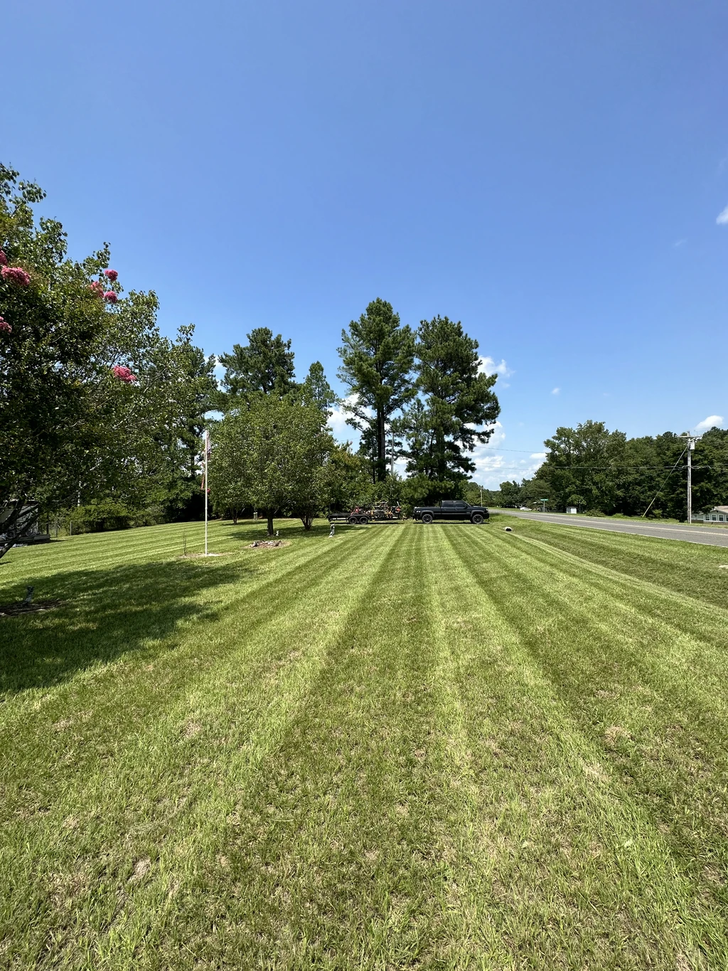 Roadside property with crisp mowing stripes maintained by Grass Geeks