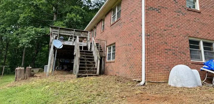 The back of the same brick house after brush clearing and haul-off